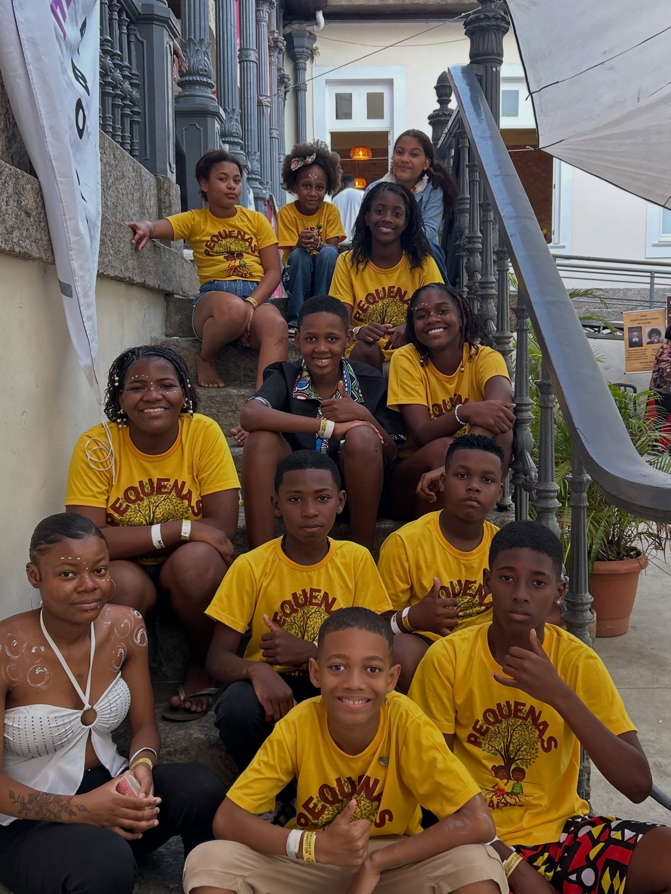 Crianças e adolescentes do Pequenas Raízes reunidos com as camisetas amarelas do projeto